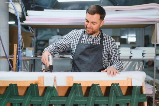 Craftsman working on upholstery in workshop